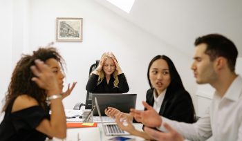 four-employees-arguing-across-desk